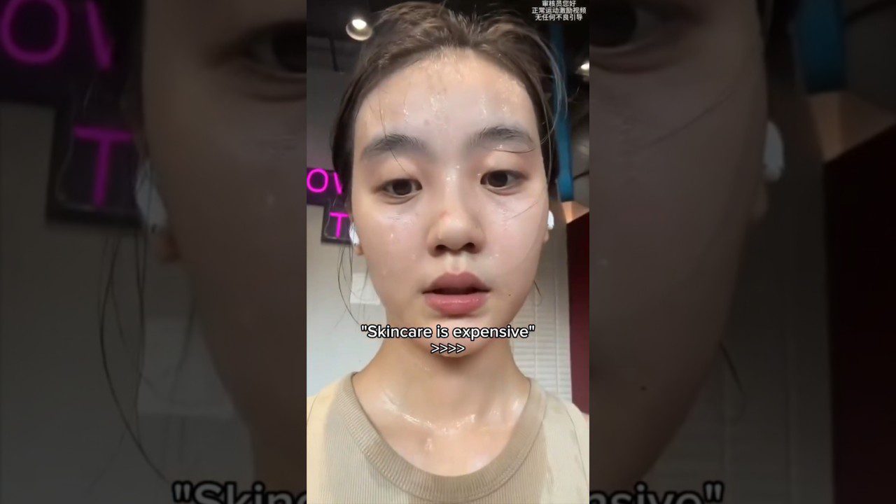 Jauna moteris su drėgna oda ir ausinėmis, ekrane užrašas „Skincare is expensive“.