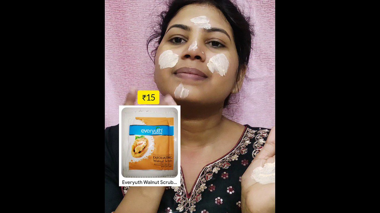 Moteris tepasi veidą baltu šveitikliu, rodoma Everyuth Walnut Scrub pakuotė ir kaina ₹15