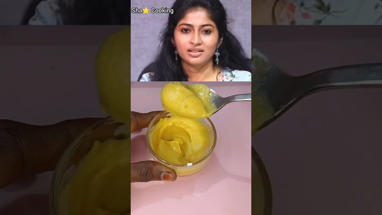 Moteris viršuje ir šaukštu paimtas kremas stikliniame indelyje ant rožinio fono