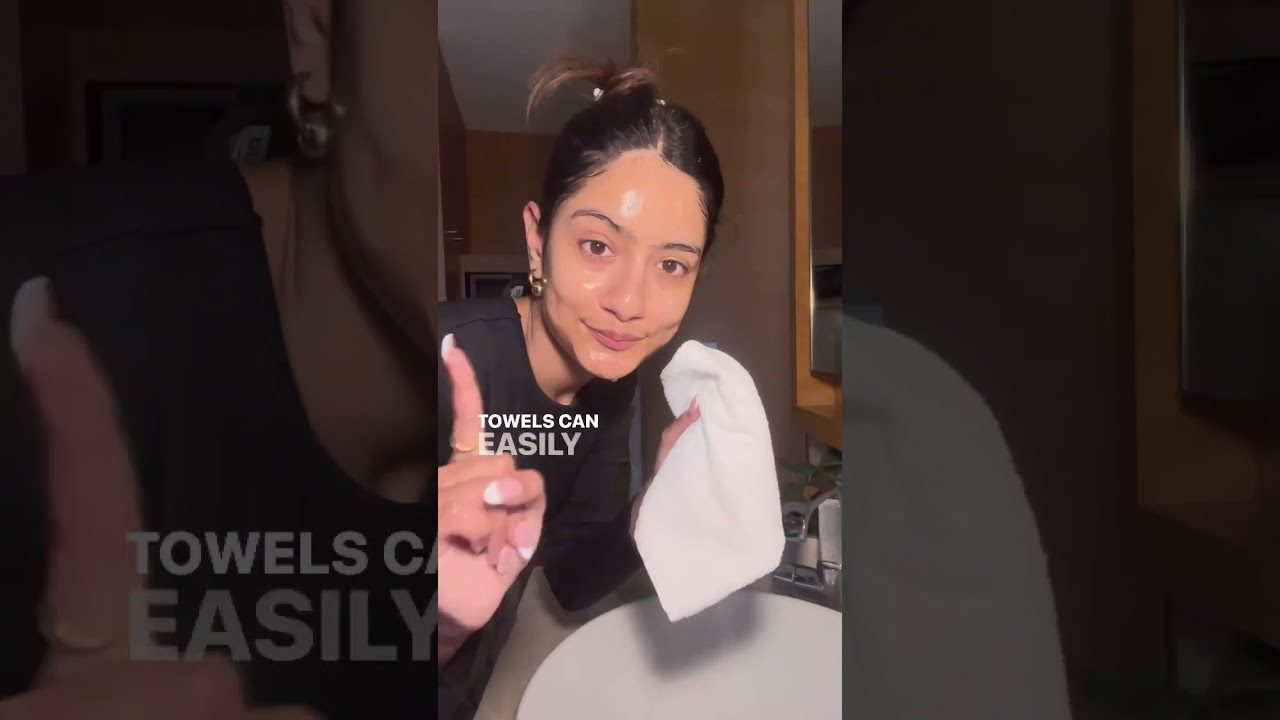 Moteris vonios kambaryje nusivalo veidą rankšluosčiu, ekrane užrašas „Towels can easily“