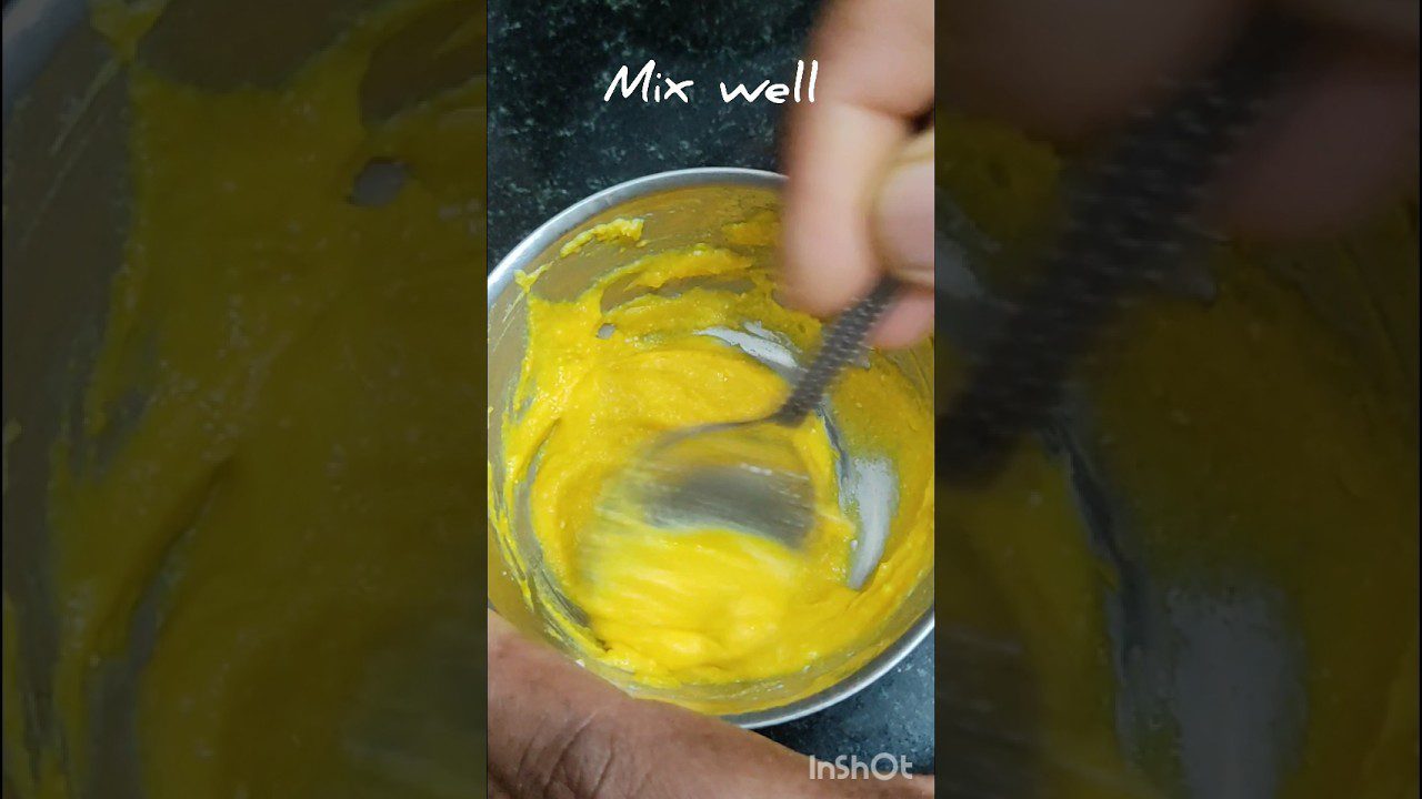 Rankomis maišoma ryškiai geltona padažo konsistencijos masė metaliniame dubenyje su užrašu „Mix well“ (sumaišyti gerai).