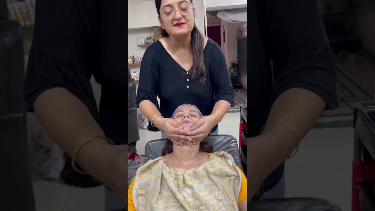 Kosmetologė masažuoja kliento veidą gulint saloninėje kėdėje, ant veido kaukė.