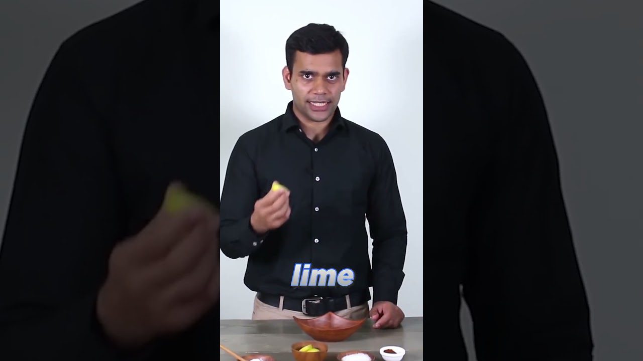 Vyras juoda marškinėliais laiko laimo gabalėlį virš medinės dubenėlio eilės ingredientų