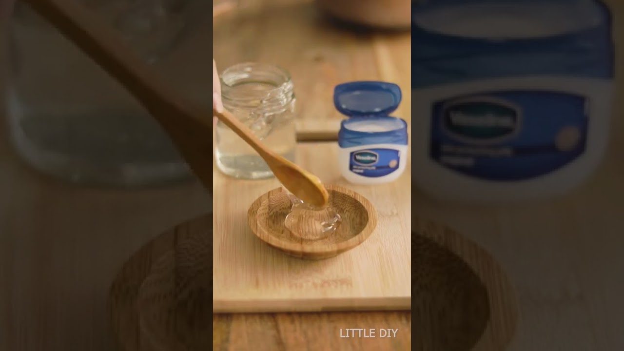 Medus ar vazelina mišinys medinėje lėkštelėje, šaukštas ir stiklainis fone