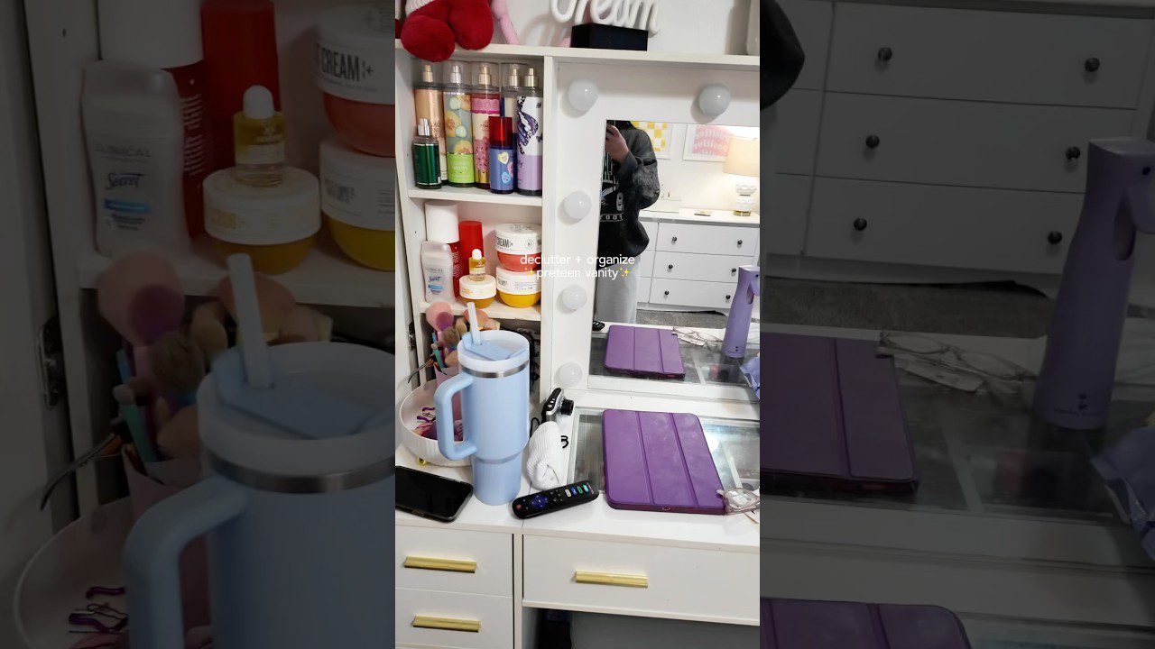 Veidrodžio makiažo stalas su kosmetika, šviesų apšvietimu, mėlytu termopuodeliu ir violetiniu planšetės dėklu