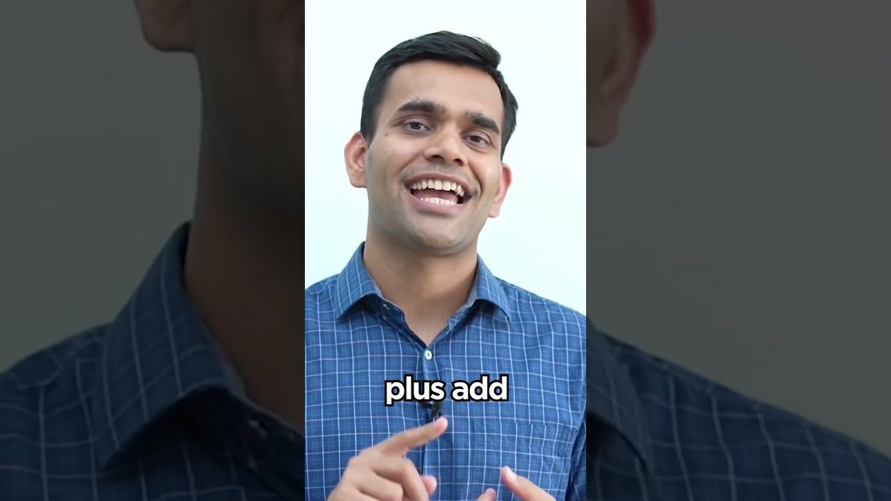 Vyras šypsosi ir gestikuliuoja, dėvi languotą mėlyną marškinių palaidinę, užraše „plus add“