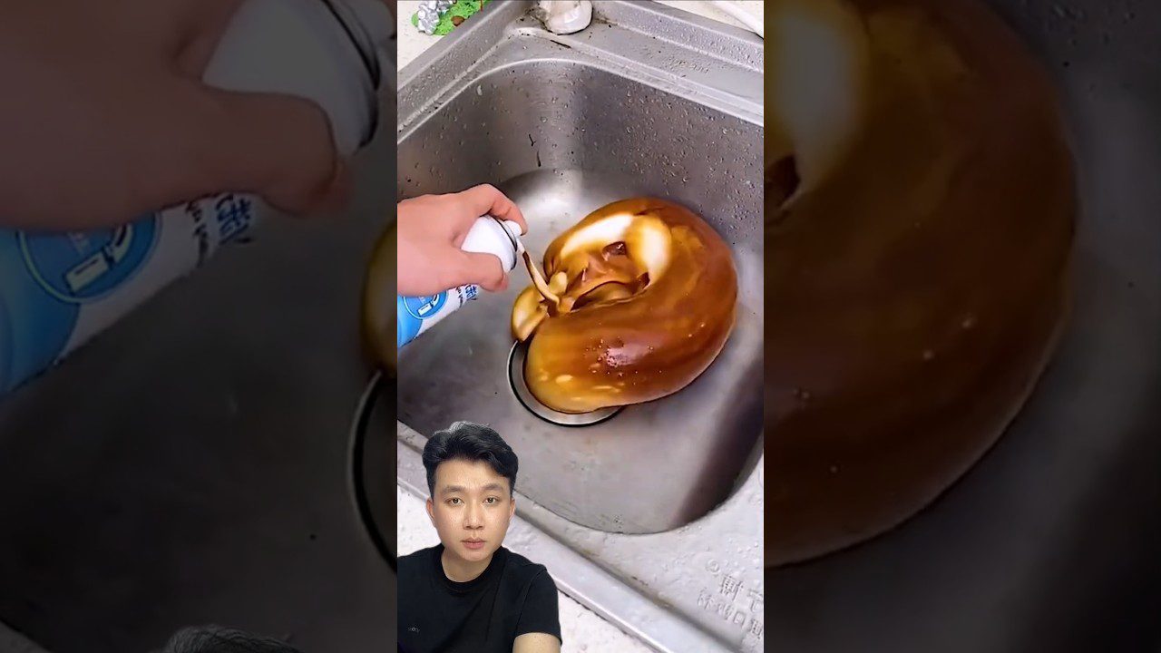 Rankos purškia putplasčio skardinės putą ant tamsaus gelio formos valymo putos kriauklėje.