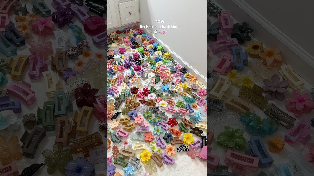 Kolekcija spalvotų plaukų segtukų ir gėlių formos aksesuarų ant balto fono