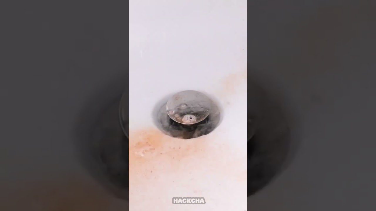 Kriauklės vandens nutekėjimas su rudais apnašų žiedais aplink kamštį