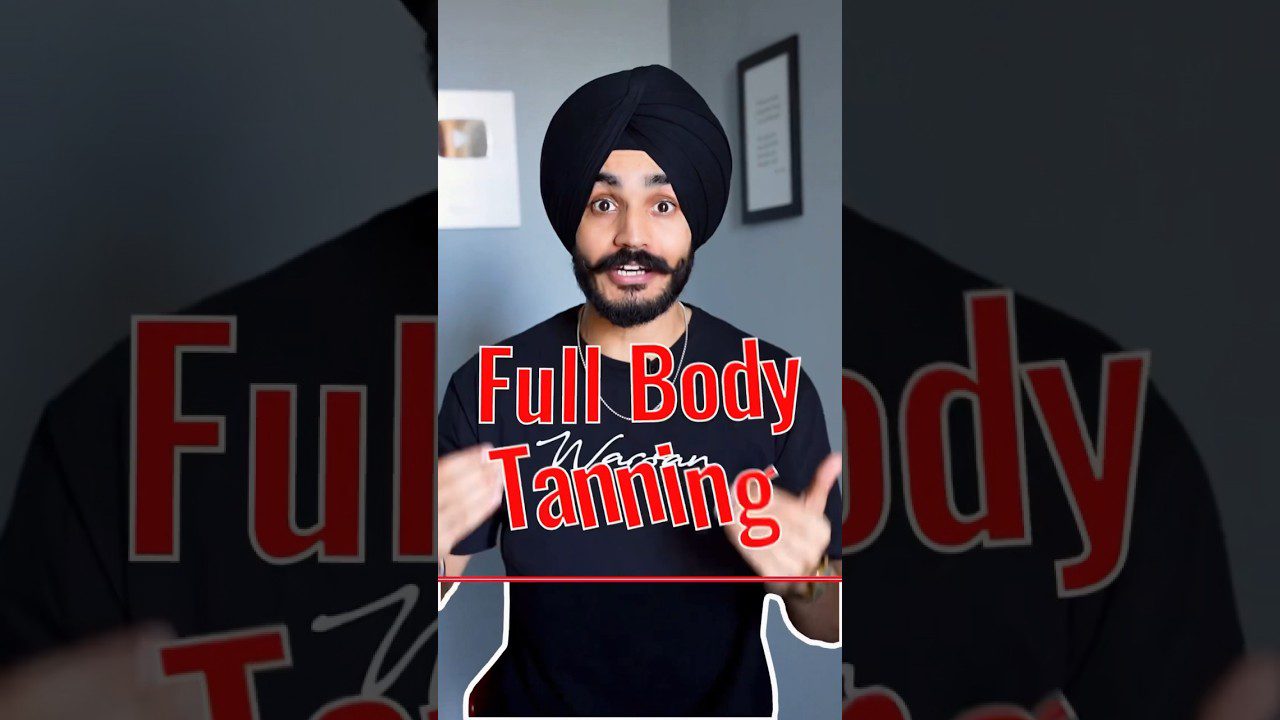 Vaikinas su turbanu ir ūsais gestikuliuoja priekiniame plane, tekstas „Full Body Tanning“ translated: pilnas kūno įdegis