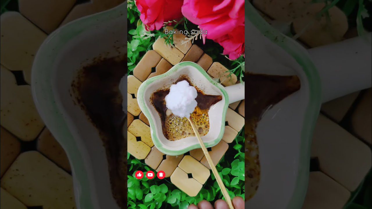 Žalios keraminės indelio viduje kepimo sodos kamuolė virš rudo skysčio ir burbulų