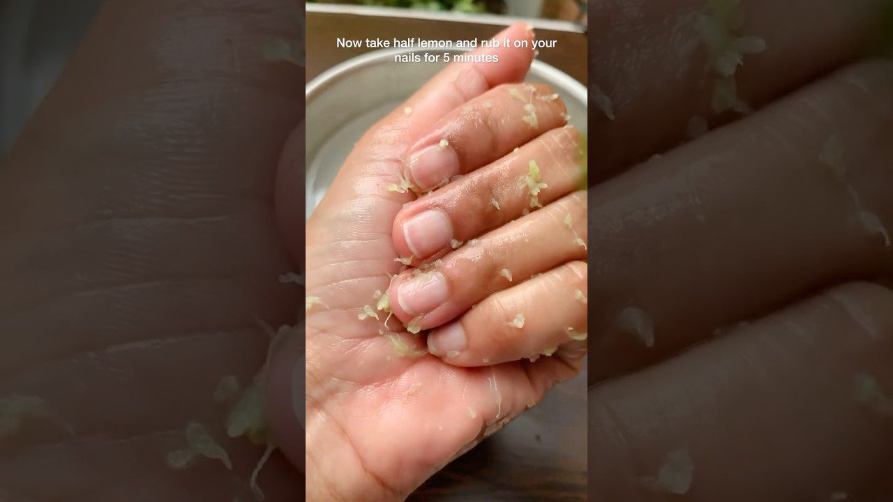 Rankų delnas su nulupinėtais citrinos žievelės gabalėliais ant odos ir nagų