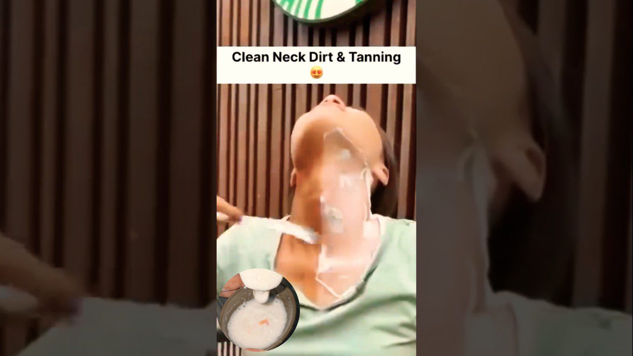 Moteris galiai atlošus galvą tepama balta pasta ant kaklo ir dekoltė zona.