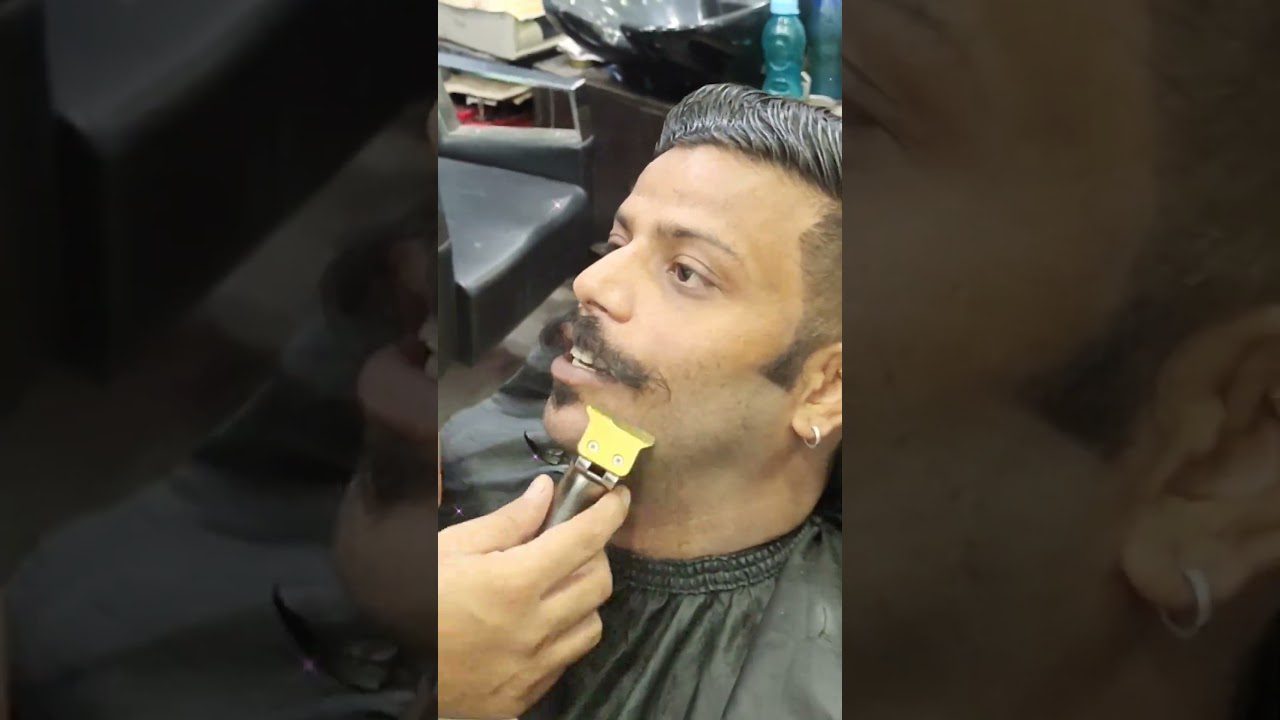 Vyrui kirpimas kirpykloje, skutamas barzdos žoliapjove prie smakro