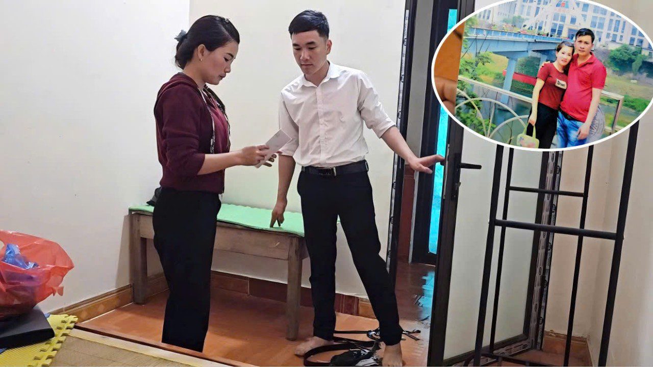 Du žmonės kambaryje skaito dokumentą prie atviros durų ir laiko raktus.