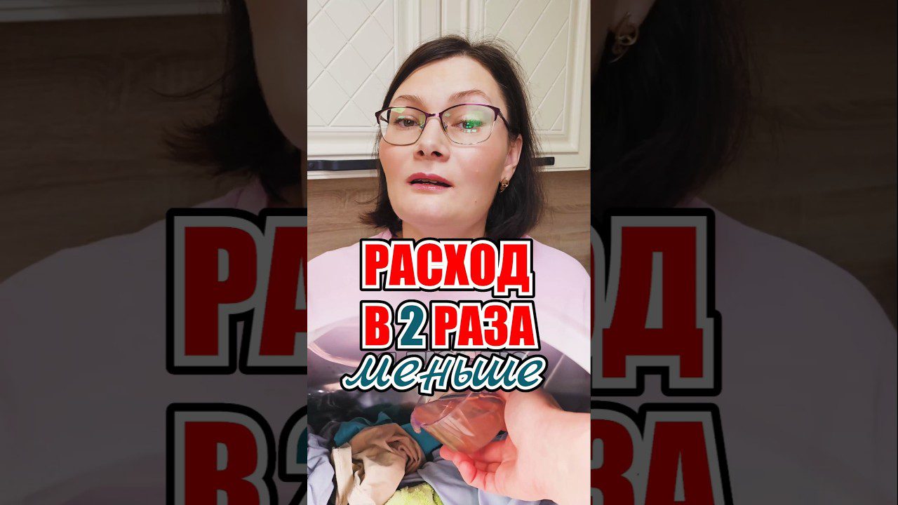 Moteris su akiniais virtuvėje, priešais skalbinių dėžę ir užrašu „sąnaudos du kartus mažesnės“