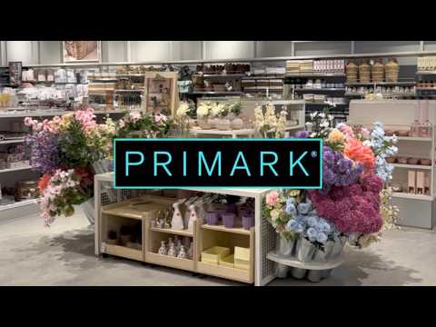 Prekybos salės stendas su dirbtinėmis gėlėmis, vazonais ir dekoracijomis, Primark logotipas.