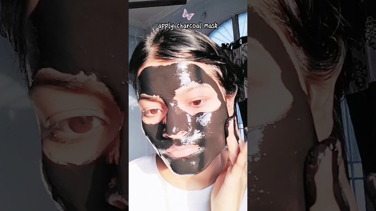 jauna moteris su juoda anglies kauke ant veido, liesianti skruostą ir žiūrinti žemyn