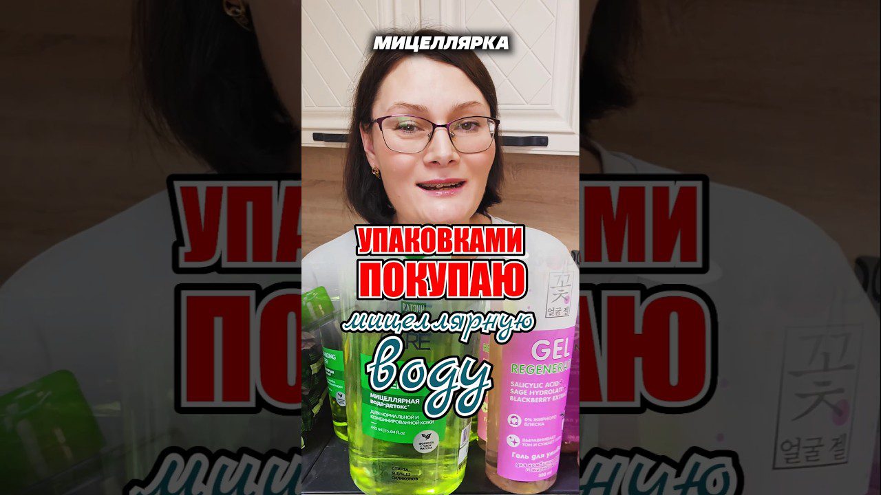 Moteris su akiniais pristato įvairias micelinio vandens pakuotes ir kosmetikos butelius.