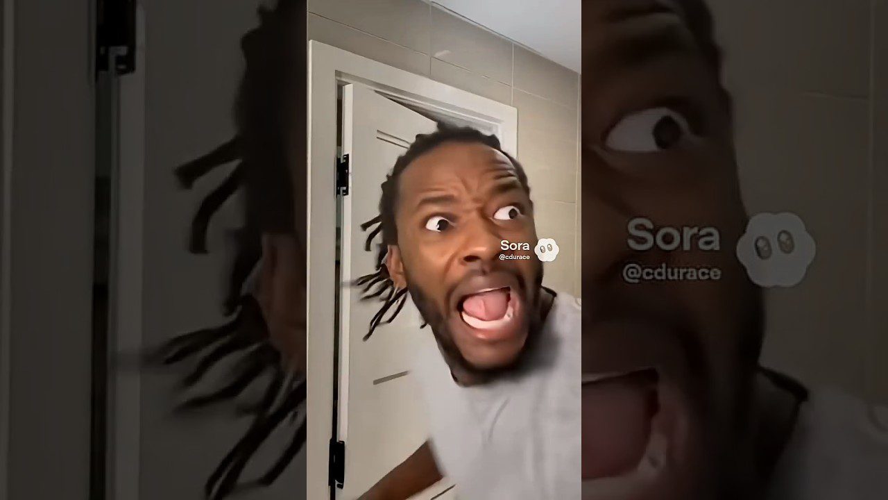 Vyras su kuodeliais išsišiepęs ir išsigandęs prie atidarytų durų, matomas tekstas "Sora".