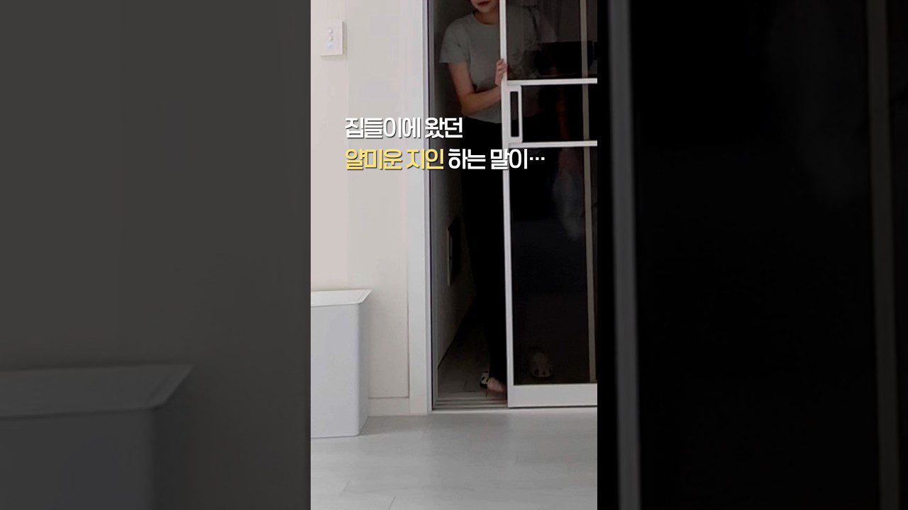 Moteris stumia duris, už jų matyti kambarys ir užrašas korėjiečių kalba.