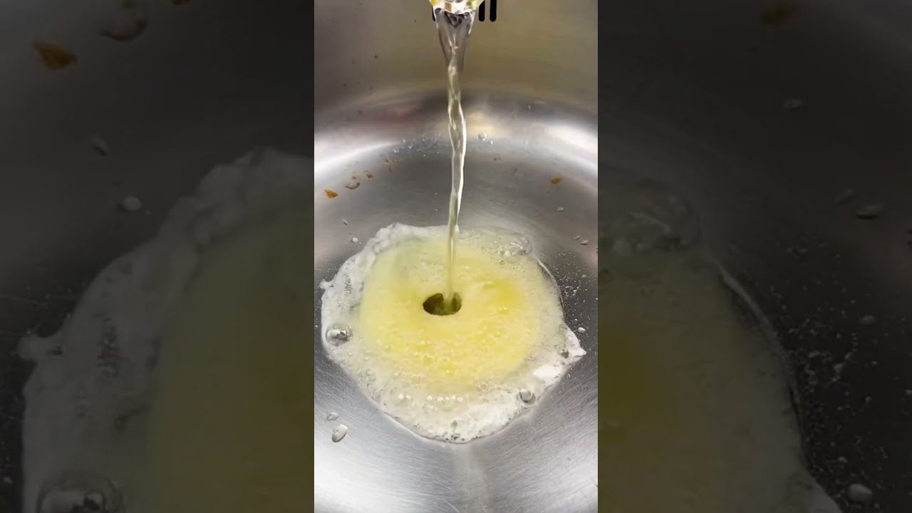 Karštas vanduo teka į kriauklę, išsiskiria gelsvas muilo putas centro linkе.