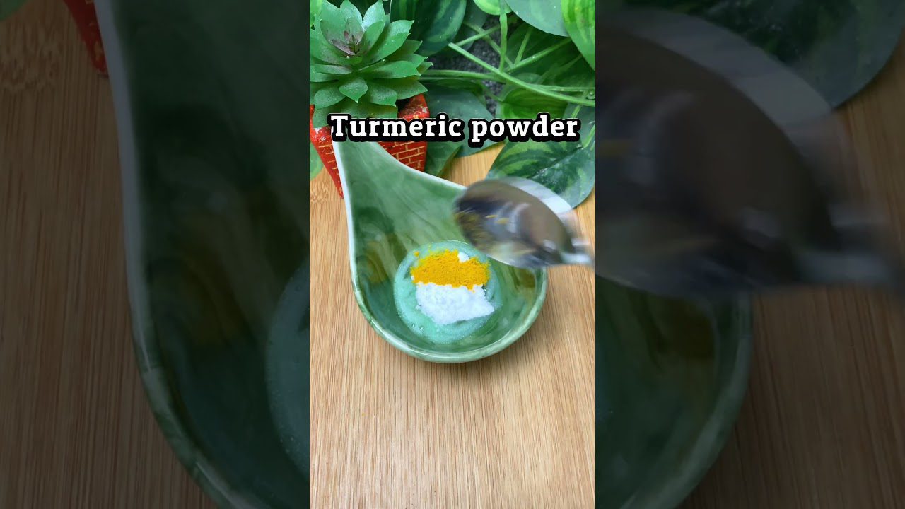 Žalias indas su kokosų druska ir ciberžolės milteliais ant medinio stalo