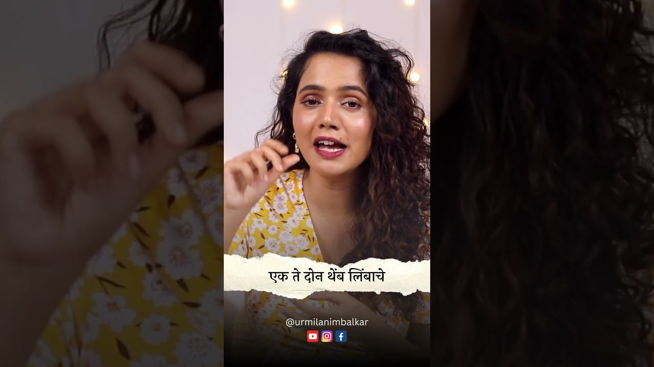 Moteris su garbanotais plaukais kalba, dėvi geltoną gėlių suknelę, matomas užrašas maratų kalba.