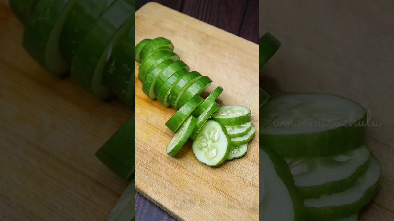 Sutrumpintas agurkas supjaustytas riekelėmis ant medinės pjaustymo lentos