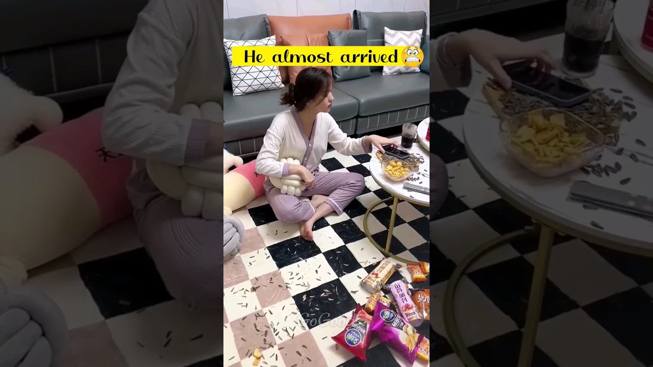 Mergina svetainėje sėdi ant grindų, aplink ją išbarstyti saulėgrąžų lukštai ir užkandžiai.