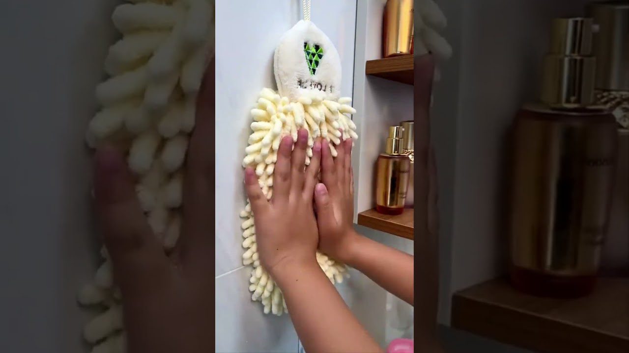 Rankos trinasi švelniu šviesiai gelsvu mikropluošto šepetėliu prie vonios plytelių