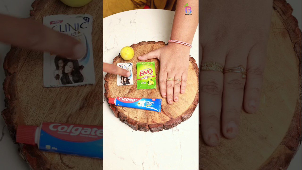 Ranka ant medinio padėklo šalia dantų pastos, ENO pakelio ir citrinos