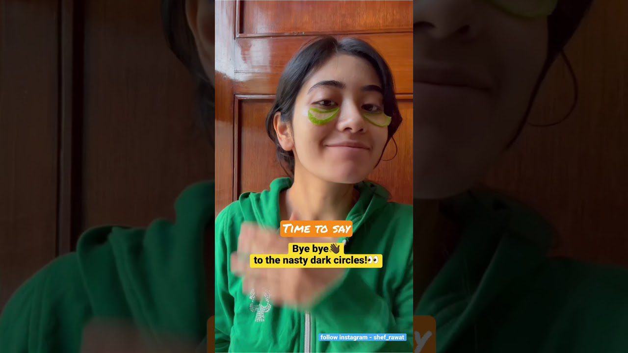 Jauna moteris su žaliais akių paakių pleistrais ir žalia džemperiu, šypsosi prie medinių durų