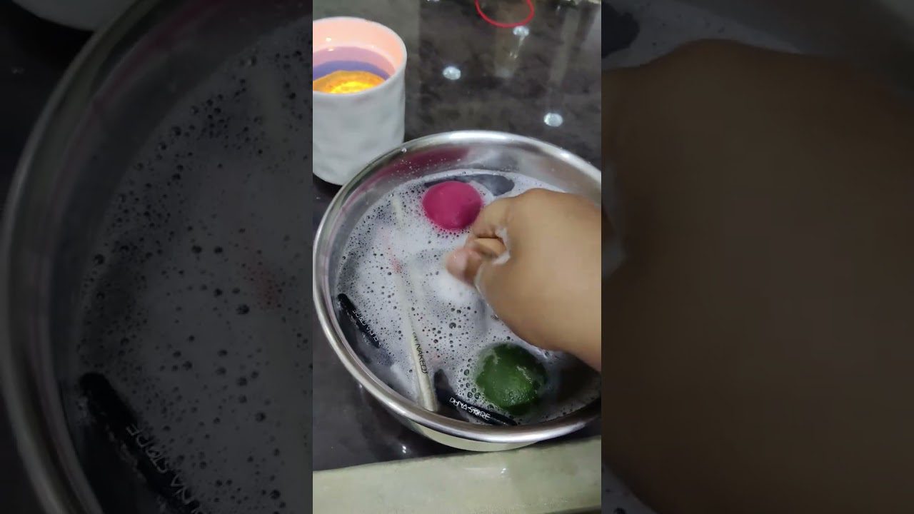 Rankos plauna makiažo kempinę ir teptukus muiluotame dubenyje prie stalo.