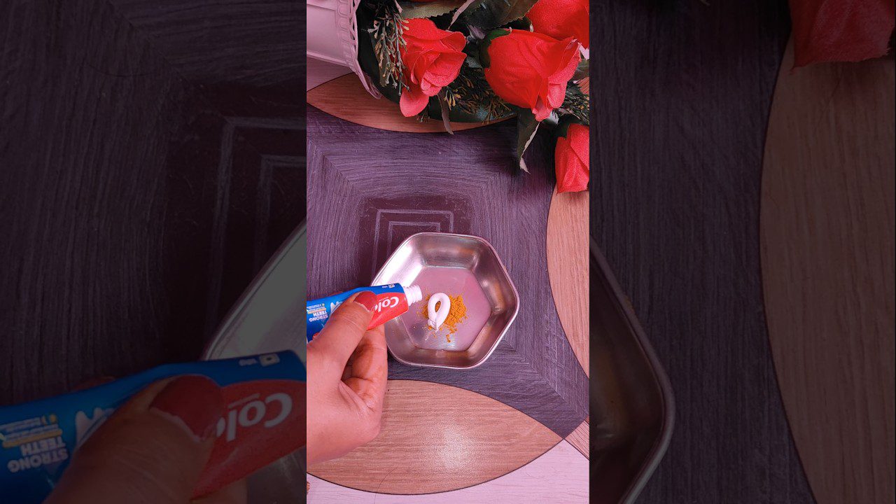 Rankos spaudžia dantų pastą į metalinį indelį šalia raudonų rožių ir prieskonio.