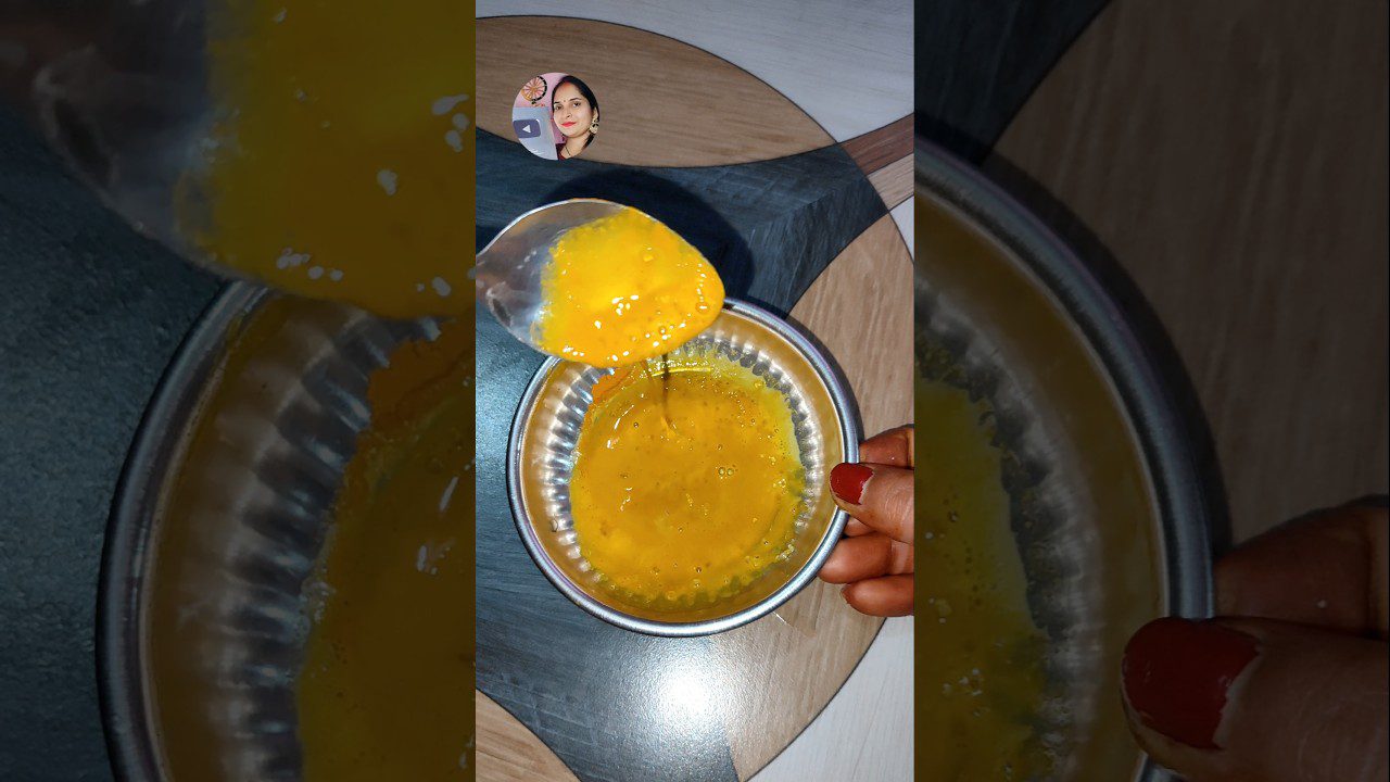 Rankos pilsto plaktą kiaušinį į metalinį indą, matomas šaukštas su geltonu kiaušiniu.