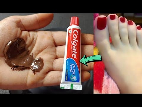 Rankomis užtepta ruda pasta, šalia Colgate dantų pastos tūtelė ir lakuoti nagai