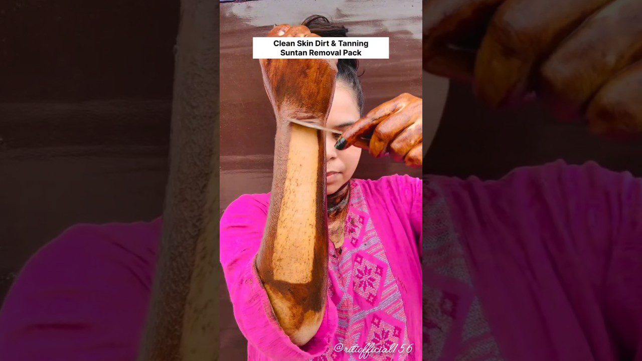 Moteris ranką padengusi tamsiu įdegio šalinimo mišiniu ir jį nušveičia peiliuku