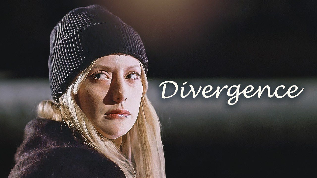 Jauna moteris su juoda kepure žiūri į šalį, šalia užrašas „Divergence“.