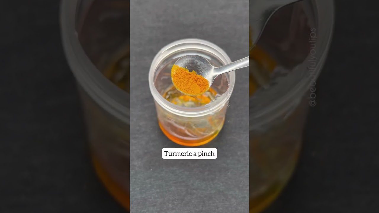 Šaukštelis ciberžolės virš stiklainio su alyvuogių aliejumi ir užrašu „Turmeric a pinch“