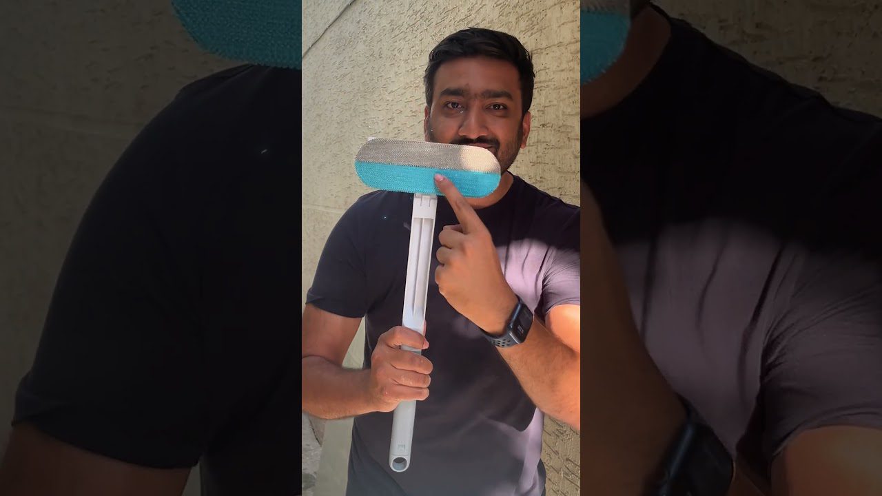 Vyras laiko ilgą valymo šepečio lazdelę ir rodo pirštu į mėlyną galvutę