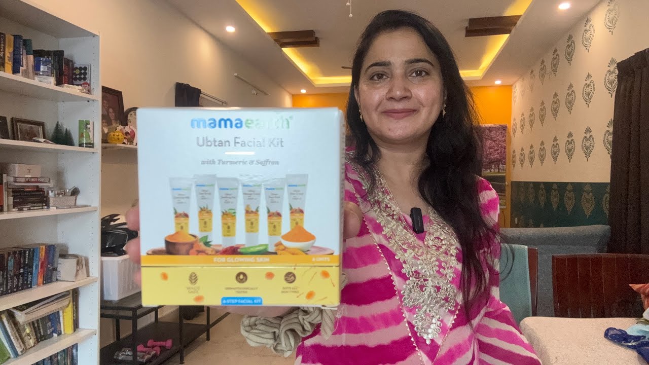 Moteris laiko dėžutę „Mamaearth Ubtan Facial Kit“ su prieskoniais, šypsosi kambaryje