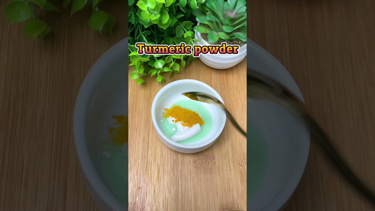 Mažas indelis su geltonomis ciberžolės milteliais ir balto kremo mišiniu ant medinio stalo