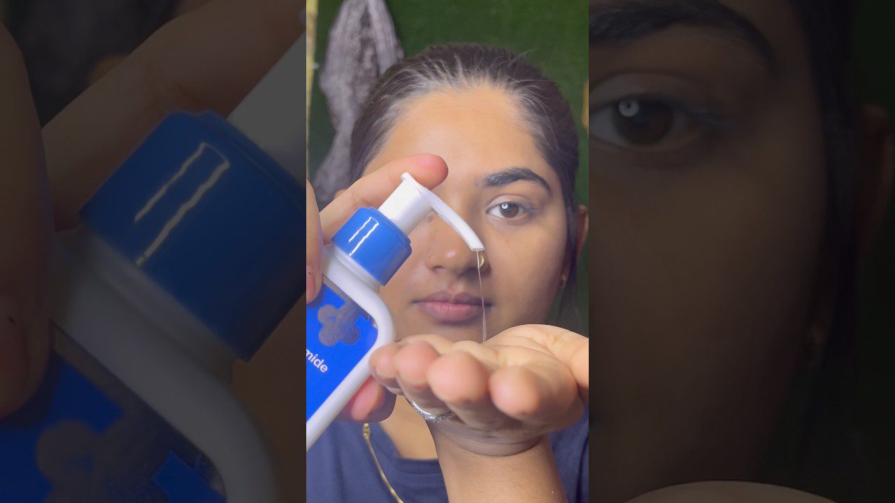 moteris pilsto skaidrų gelį iš balto mėlyno dozatoriaus ant atviros delno, veidas fone