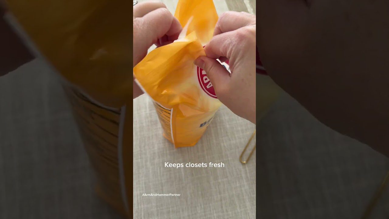 Rankos atlenkia geltoną pakuotę dezodoranto su tekstu „Keeps closets fresh“ išverstu į lietuvių kalbą.