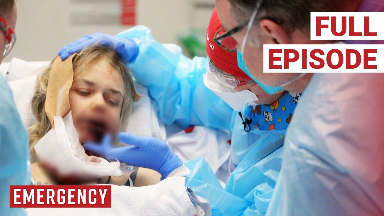 Medikai apsaugine apranga gydo sužalotą pacientę prie ligoninės lovos, užrašai: „Skubioji pagalba“, „Pilnas epizodas“