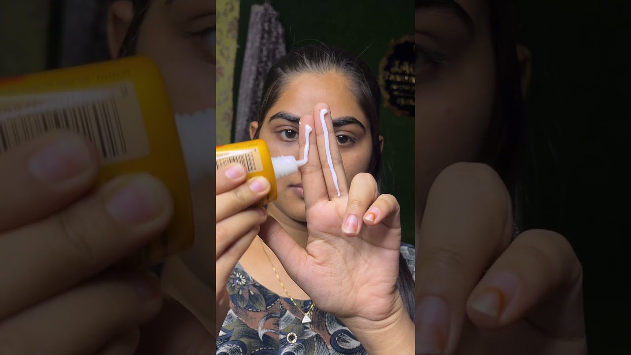 Moteris švelniai tepa baltą kremą ant dviejų pirštų, paruošdama veidą