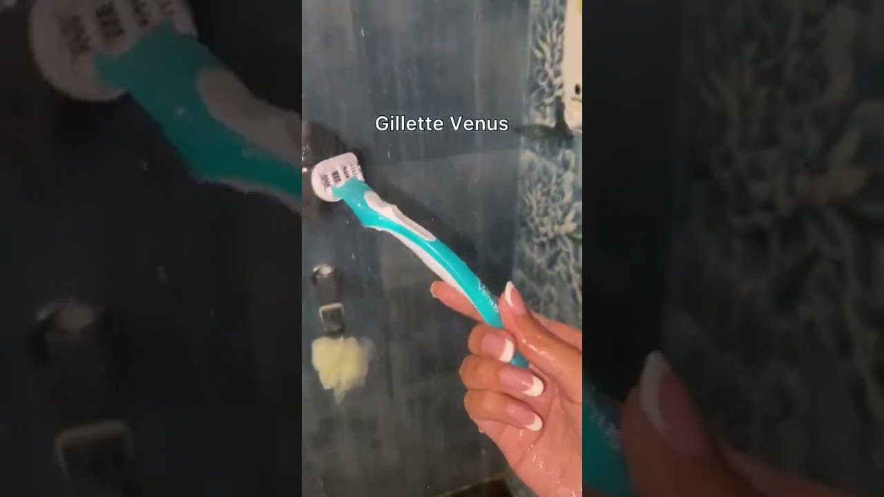 Rankoje laikoma turkio spalvos Gillette Venus skustuvė su baltu galvute ir nagais su prancūzišku manikiūru