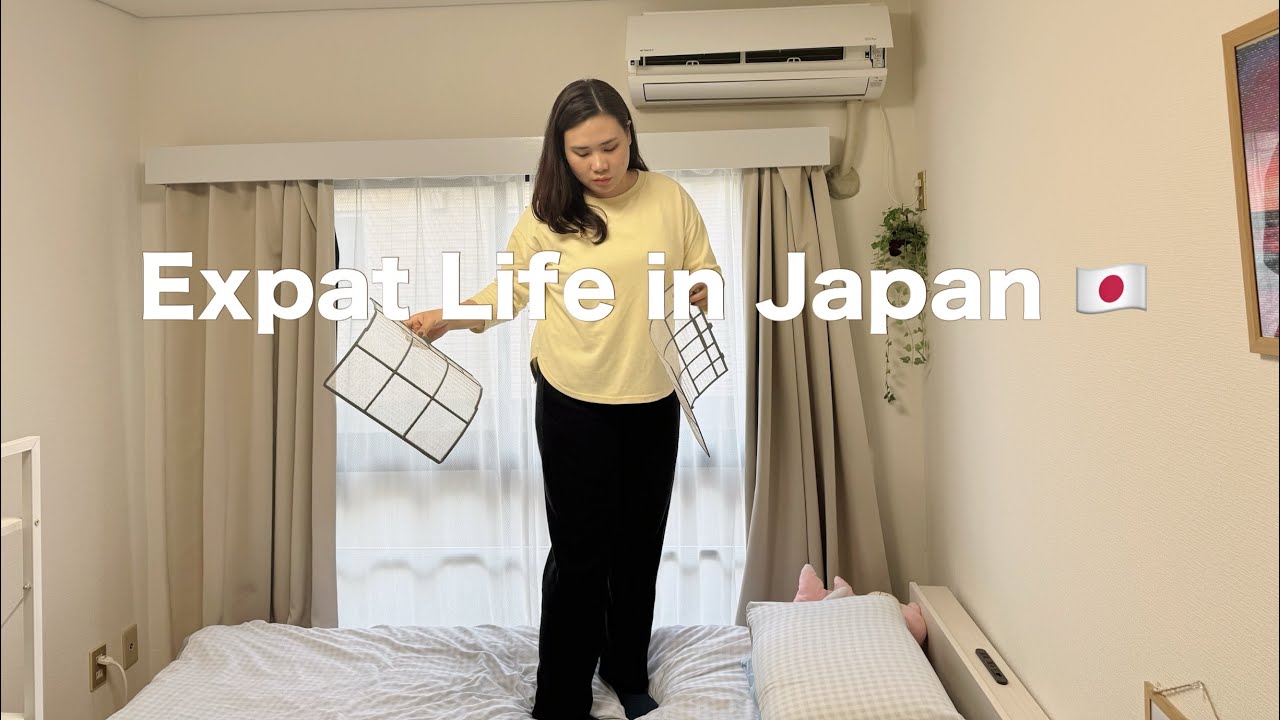 Moteris stovi ant lovos Japonijos bute ir laiko oro filtrus, tekstas „Expat Life in Japan“