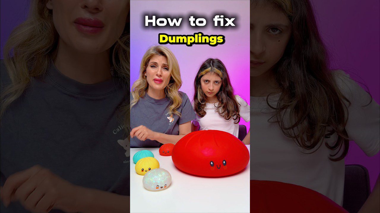 Moteris ir mergaitė prie stalo su ryškiai raudonu dideliu žaislu „dumplings“ ir mažais žaislais